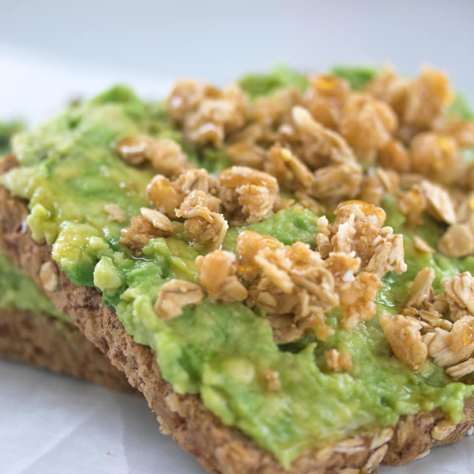 Avocado toast on 7-grain bread topped with fresh sprouts and seasoning