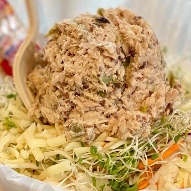 Scoop of tuna salad served over a bed of the Super Salad with wheat crackers