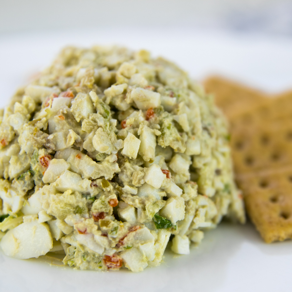 Scoop of signature egg salad with celery and green olives, served with crackers